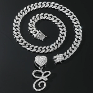 Detail of silver iced-out Cuban link necklace with heart and E letter pendant