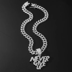 Macro shot of silver Cuban chain necklace with iced-out NEVER GIVE UP letter pendant