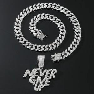 Macro detail of iced-out NEVER GIVE UP pendant on a silver Cuban link chain