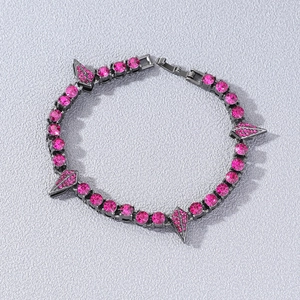 Bracelet style punk en métal noir avec strass roses et pointes sur fond gris clair