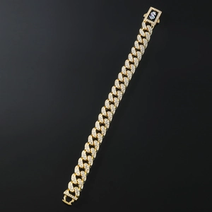 Macro shot of gold Cuban link bracelet with diamond inlay and silver dollar sign clasp