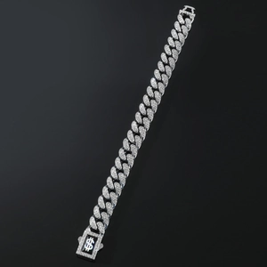 Detailed close-up of a silver Cuban link bracelet with clear crystals and dollar sign clasp