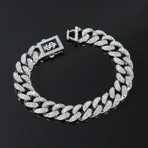 Detailed close-up of iced-out silver Cuban chain bracelet with dollar sign clasp