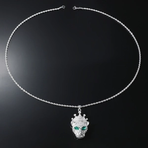 Detailed macro of a silver crown leopard pendant with green eyes and crystal pave