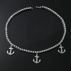 Gros plan de pendentifs d'ancre en argent avec cordes et chaîne de strass sur miroir noir