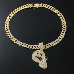 Close-up of gold hip hop pendant with middle finger emoji and iced out Cuban link chain