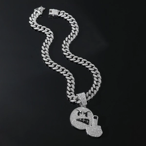 Detail of hip hop Cuban link necklace with iced out emoji and middle finger pendants