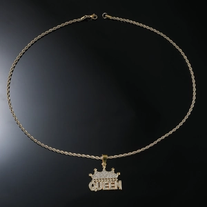 Detailed macro shot of a gold-plated crown queen pendant with iced-out crystals on rope chain