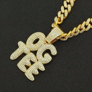 Gros plan du pendentif lettre FREE serti de strass sur une chaîne cubaine dorée hip hop