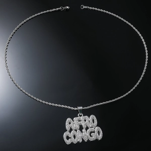 Détail macro du pendentif Afro Congo avec chaîne de corde argentée sur fond noir