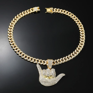 Détail macro du pendentif Shaka hip-hop plaqué or avec zircons étincelants sertis pavé
