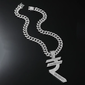 Macro detail of iced out silver Cuban chain with large rupee symbol pendant and zircons