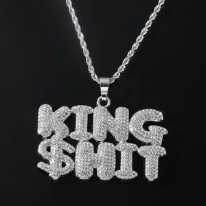 Close-up of iced-out KING $HIT letter pendant with sparkling crystals on rope chain
