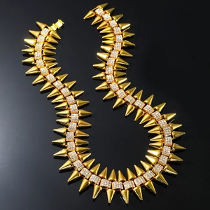 Collier ras du cou hip hop à pointes dorées avec strass brillants sur fond noir mat