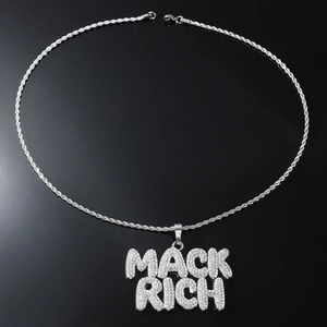 Nahaufnahme des silbernen MACK RICH Anhängers mit glitzernder Seilkette-Details