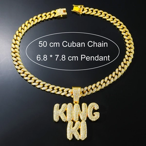 Detail of iced out King Ki pendant on a 50cm golden Cuban chain with white rhinestones