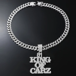 Détail d'une chaîne cubaine hip hop argentée avec grand pendentif 81 KING OF CARZ