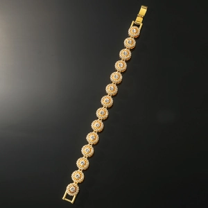 Close-up of gold hip-hop bracelet showing sparkling pavé crystals on circular links