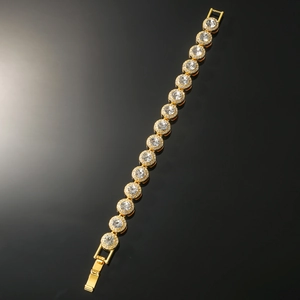 Detailed close-up of golden Cuban link bracelet with round pavé diamonds and fold-over clasp