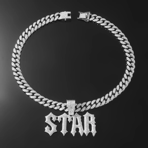 Macro view of iced out silver STAR pendant and cuban link chain with zircon stones