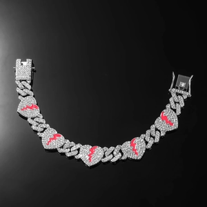 Iced-out Cuban chain heart bracelet with red enamel lightning detail on black background