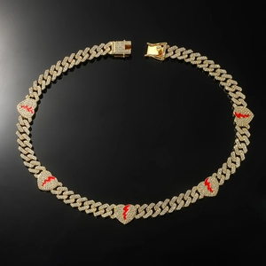 Macro detail of gold Cuban chain necklace with iced-out broken heart pendants and zircons