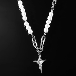 Collana a croce stellata con perle e catena d'argento su specchio nero lucido
