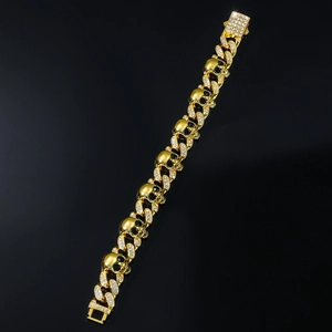 Dettaglio del bracciale hip hop a teschio dorato con maglie cubane in zirconi pavé