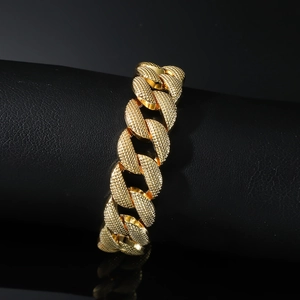 Men's hip hop gold Cuban link bracelet with textured sandblasted finish on black stand