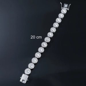 Iced out silver tennis bracelet with circular crystal links on black reflective surface