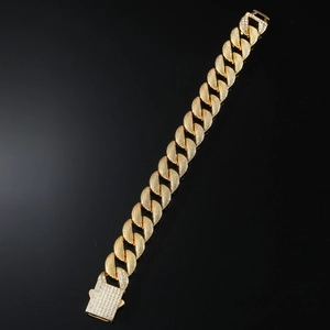 Detailed close-up of golden Cuban link bracelet with micro-pave zircon buckle on black mirror