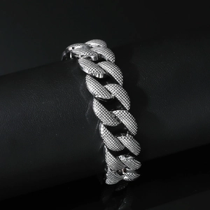 Polished silver cuban link bracelet with textured grainy surface in hip hop style