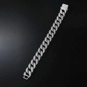 Close-up of iced out silver Cuban link bracelet with diamond-set security clasp