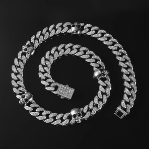 Détail du collier chaîne cubaine argentée avec crânes et zircons sur fond sombre