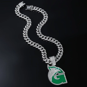 Détail de chaîne cubaine argentée avec pendentif lettre G loup émaillé vert et cristaux