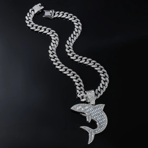 Détail du pendentif requin serti de strass baguettes sur une grosse chaîne cubaine