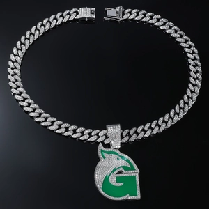 Détail d'une chaîne cubaine hip-hop avec pendentif lettre G verte et tête d'animal sertie