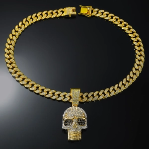 Macro view of gold Cuban link chain with a sparkling pavé diamond skull pendant details