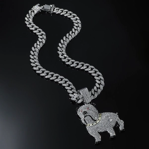 Dettaglio macro del ciondolo bulldog con zirconi e occhi rossi su grossa catena cubana