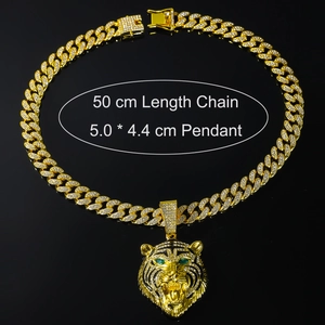 Detail of 50cm golden Cuban chain with lion head pendant featuring green eyes and zircons