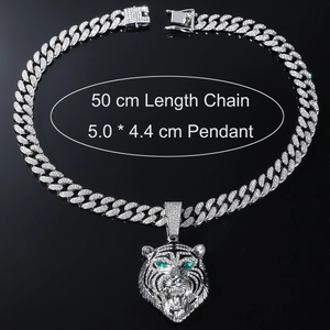 Detailed close-up of iced out hip hop lion pendant with green eyes and Cuban link chain