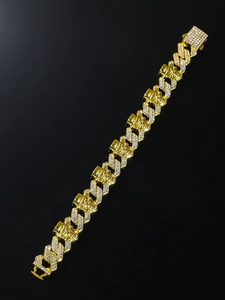 Close-up of golden skull link bracelet with pavé-set crystals in a hip-hop style