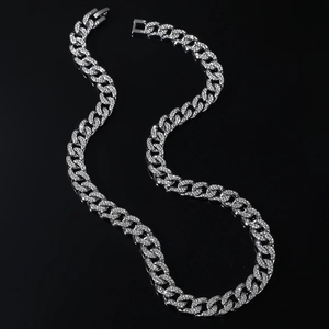 Collier maille cubaine argenté pavé de diamants disposé en S sur fond noir brillant