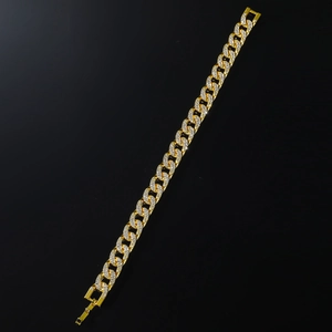 Dettaglio macro del bracciale a maglie cubane dorate con pavé di cristalli lucidi