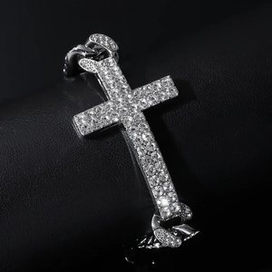 Detailed close-up of a silver punk cross bracelet with iced-out rhinestones on Cuban links