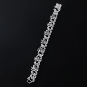 Detail of hip hop iced out Cuban link bracelet with skull carving on polished metal