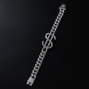 Détail macro du bracelet à mailles cubaines argentées avec breloque dollar sertie