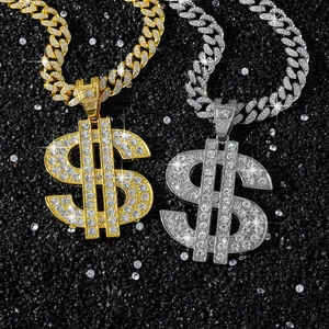 Close-up of gold and silver iced-out dollar sign pendants with heavy Cuban link chains