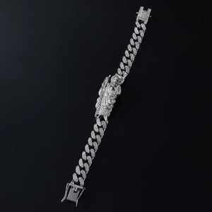 Macro shot of silver hip-hop Cuban link bracelet with iced-out St. Jude portrait pendant