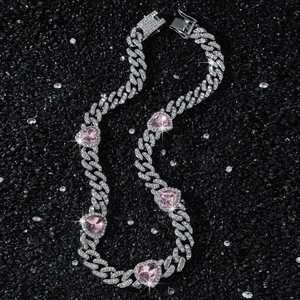 Chaîne cubaine argentée sertie avec pendentifs cœurs roses sur fond pailleté noir